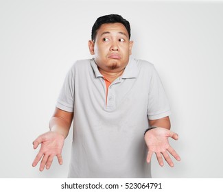 Photo Image Portrait Of A Cute Young Asian Man Showing I Don't Know Gesture, Shoulder Shrug And Looking To The Side