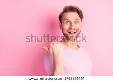 Photo of impressed cheerful guy open mouth smile indicate thumb empty space offer isolated on pink color background