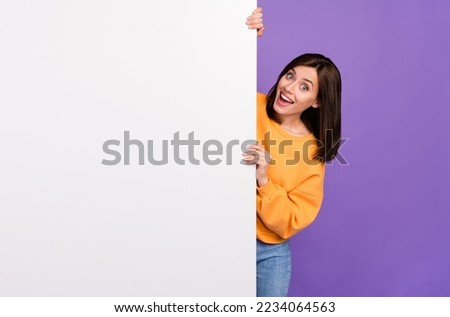 Photo of impressed cheerful lady wear trendy pullover hand hold present big poster empty space isolated purple color background