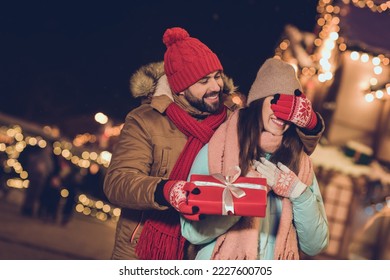Photo of impressed excited girlfriend boyfriend getting gift package walking outdoors urban city market
