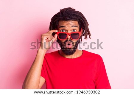 Photo of impressed funky dark skin man dressed red t-shirt arm hand eyeglasses big eyes isolated pink color background