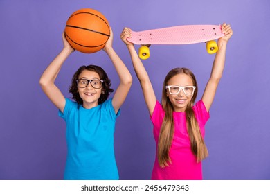 Photo of impressed funky friends wear t-shirts rising basketball ball longboard isolated violet color background