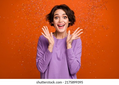 Photo of impressed funky lady wear violet sweatshirt rising arms air flying confetti isolated orange color background - Shutterstock ID 2175899395