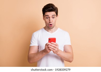 Photo of impressed handsome person open mouth staring screen unfollow isolated on beige color background
