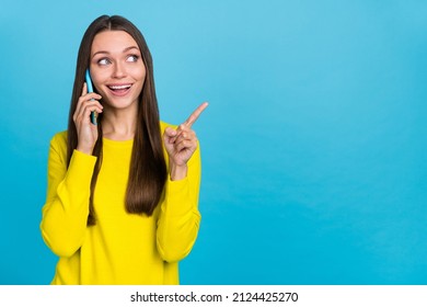 Photo of impressed millennial brunette lady talk telephone indicate promo wear yellow shirt isolated on blue background - Shutterstock ID 2124425270