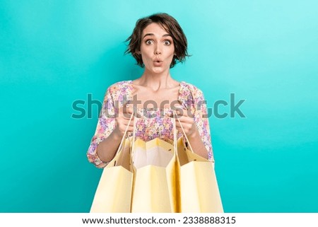 Photo of impressed pretty girl arms hold store mall bags pouted lips unbelievable reaction isolated on teal color background