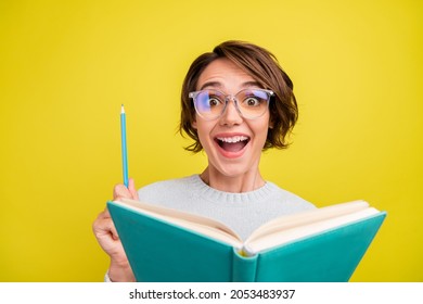 Photo of impressed young brunette lady read book wear eyeweear blue sweater isolated on yellow color background - Shutterstock ID 2053483937
