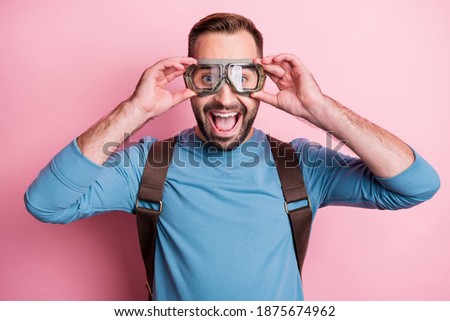 Photo of impressed young man dressed blue sweater arms eyewear rucksack ready jump parachute isolated pink color background