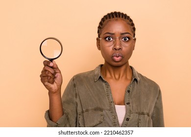 Photo Of Impressed Young Person Pouted Lips Hold Magnifier Lens Loupe Isolated On Beige Color Background