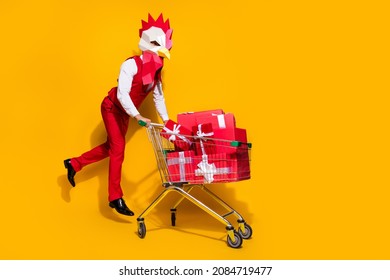 Photo Of Incognito Client Hold Market Trolley Packages Jump Wear Cock Mask Red Suit Isolated Yellow Color Background