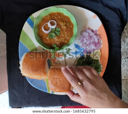 photo of an Indian recepe Pav bhaji serving with two human hands