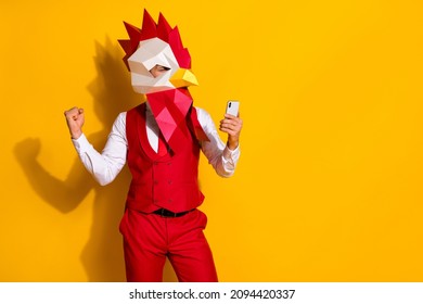 Photo of influencer guy hold telephone rejoice hundred likes wear cock mask red suit isolated yellow color background