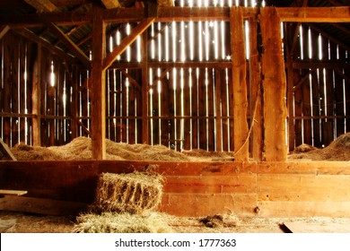 Photo inside a barn with light streaming in through siding.
