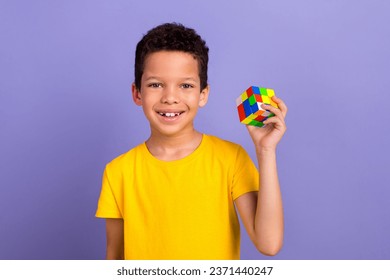 Photo of intelligent nice boy wear yellow trendy clothes hand hold colorful cube isolated on purple color background