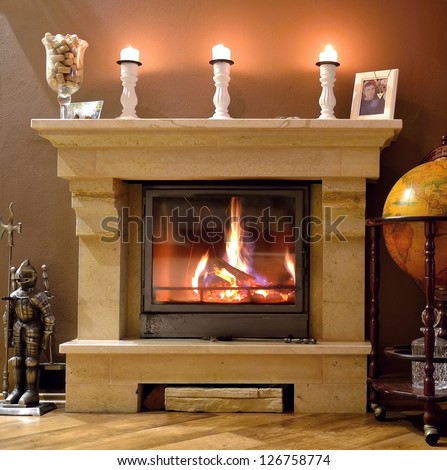 Photo interior of a home with a burning fireplace, candles and decorations. 
Ready for gifts for Christmas.