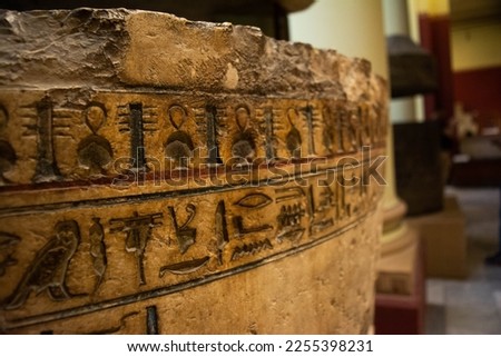 Photo of intricate hieroglyphics carved on the wall of an Egyptian tomb. The ancient form of writing and funerary art are combined in this striking image.