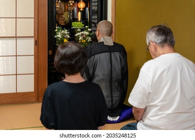 A Photo Of A Japanese Monk Praying At A Buddhist Altar