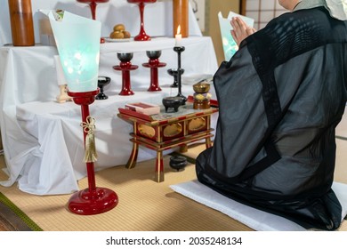 A Photo Of A Japanese Monk Praying At A Buddhist Altar