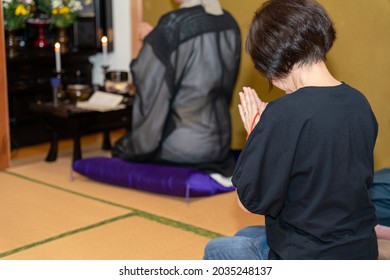 A Photo Of A Japanese Monk Praying At A Buddhist Altar