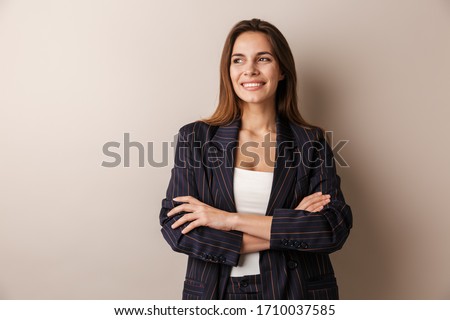 Photo of joyful businesswoman in formal suit laughing with arms crossed isolated over white background