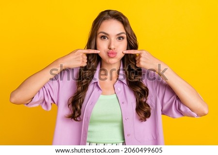 Photo of joyful funny cheerful positive woman hold fingers cheeks hold breath funky face isolated on yellow color background