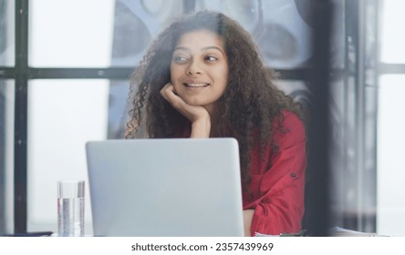 Photo of joyful nice woman using laptop and smiling while sitting - Shutterstock ID 2357439969