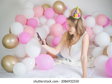 Photo Of Joyful Woman Smiling And Taking Selfie Photo On Cellphone  With Balloon. Birthday Party