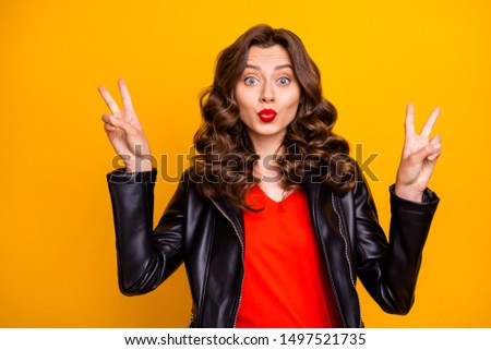 Photo of lady with amazing red lipstick showing v-signs and sending air kisses wear leather jacket isolated yellow background