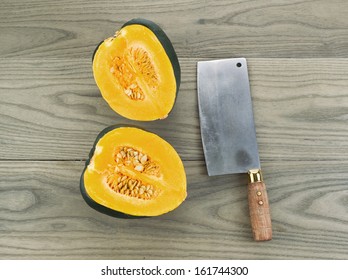 Photo Of Large Acorn Squash Cut In Half With Butcher Knife On Aging White Ash Wood 