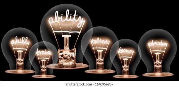 Photo of light bulb group with shining fibers in ABILITY, SKILL, TRAIN, TALENT, LEARN and EDUCATION shape isolated on black background