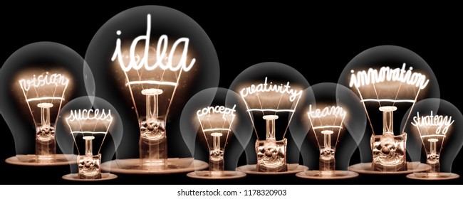 Photo of light bulbs with shining fibers in shapes of IDEA and INNOVATION concept related words isolated on black background