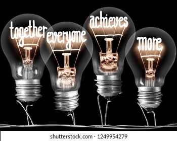 Photo of light bulbs with shining fibers in a shape of TOGETHER, EVERYONE, ACHIEVES, MORE concept words isolated on black background