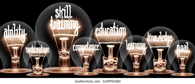 Photo of light bulbs with shining fibers in a shape of SKILL TRAINING concept related words isolated on black background