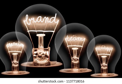 Photo of light bulbs with shining fibres in IDEA, VISION, CONCEPT and CREATIVITY shape on black background