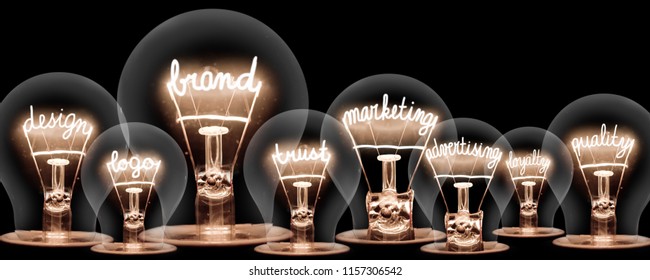 Photo of light bulbs with shining fibres in shape of BRAND concept related words isolated on black background