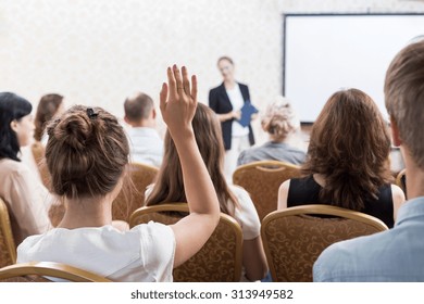 Photo of listener raising hand to ask question during seminar - Shutterstock ID 313949582