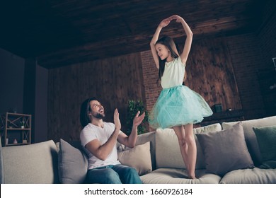 Photo Of Little Energetic Pretty Lady Excited Handsome Daddy Watching Daughter School Dance Raise Hands Like Ballerina Sitting Sofa Clapping Arms Ovation House Room Indoors