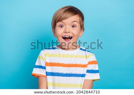 Photo of little funny blond boy wear white t-shirt isolated on blue color background