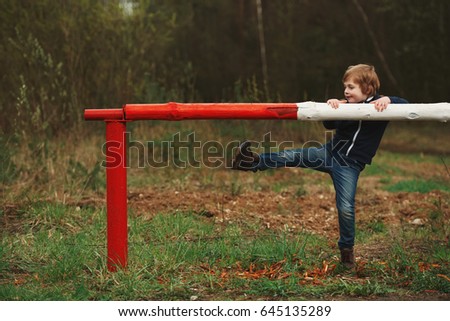 photo of little playful boy with barrier
