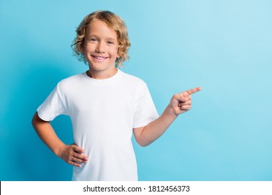 Photo of little positive boy point index finger empty space for promotion wear white t-shirt isolated on blue color background - Shutterstock ID 1812456373
