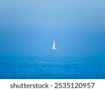 Photo of a lone sailboat at sea