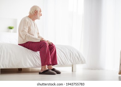 Photo of lonely frustrated age pensioner sleepwear sitting bed looking window inside indoors home room - Powered by Shutterstock