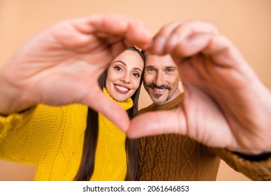 Photo Of Lovely Brunette Couple Hold Heart Wear Autumn Knitwear Sweater Isolated On Beige Color Background