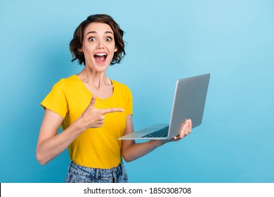 Photo of lovely girl hold netbook open mouth direct finger wear yellow t-shirt isolated blue color background - Shutterstock ID 1850308708