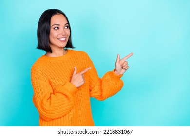 Photo of lovely good mood girl with straight hairdo dressed orange pullover directing look empty space isolated on teal color background - Shutterstock ID 2218831067