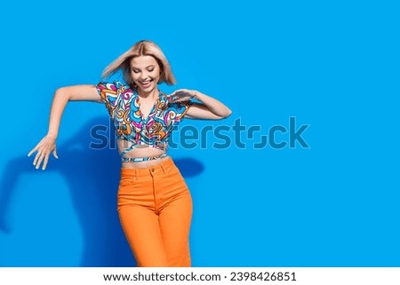 Photo of lovely overjoyed girl hands make moves dance wear cropped top empty space isolated on blue color background