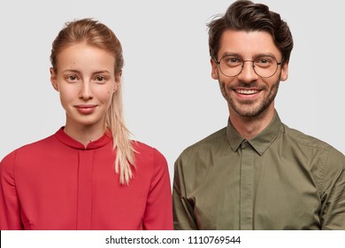 Photo Of Lovely Young Female In Red Blouse Meets With Her Older Brother, Feels Support Near His Strong Shoulder, Pose Together Against White Background. Glad Young Male Professor With Student