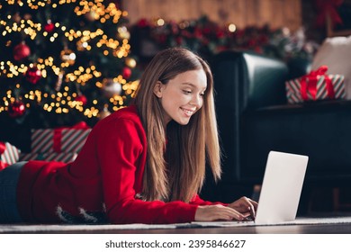 Photo of lying on carpet at home young woman brown hair teenager texting laptop her friends about received gifts in christmas midnight
