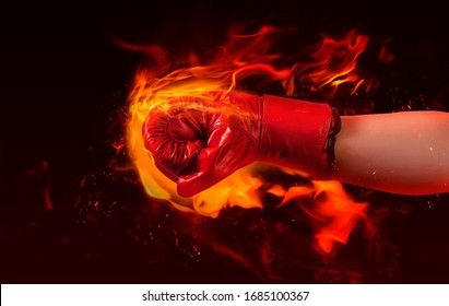 Photo of male hand in red boxing glove punching fire on burning background.