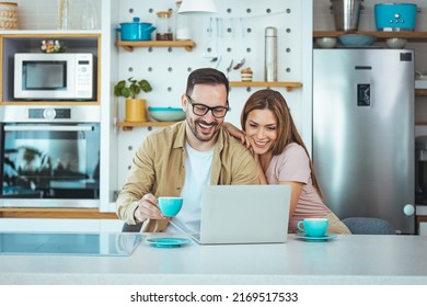 A photo of a male model looking for information on a laptop computer, looking for a new apartment for rent, drinking morning coffee, a woman standing close with a smile on her face - Powered by Shutterstock